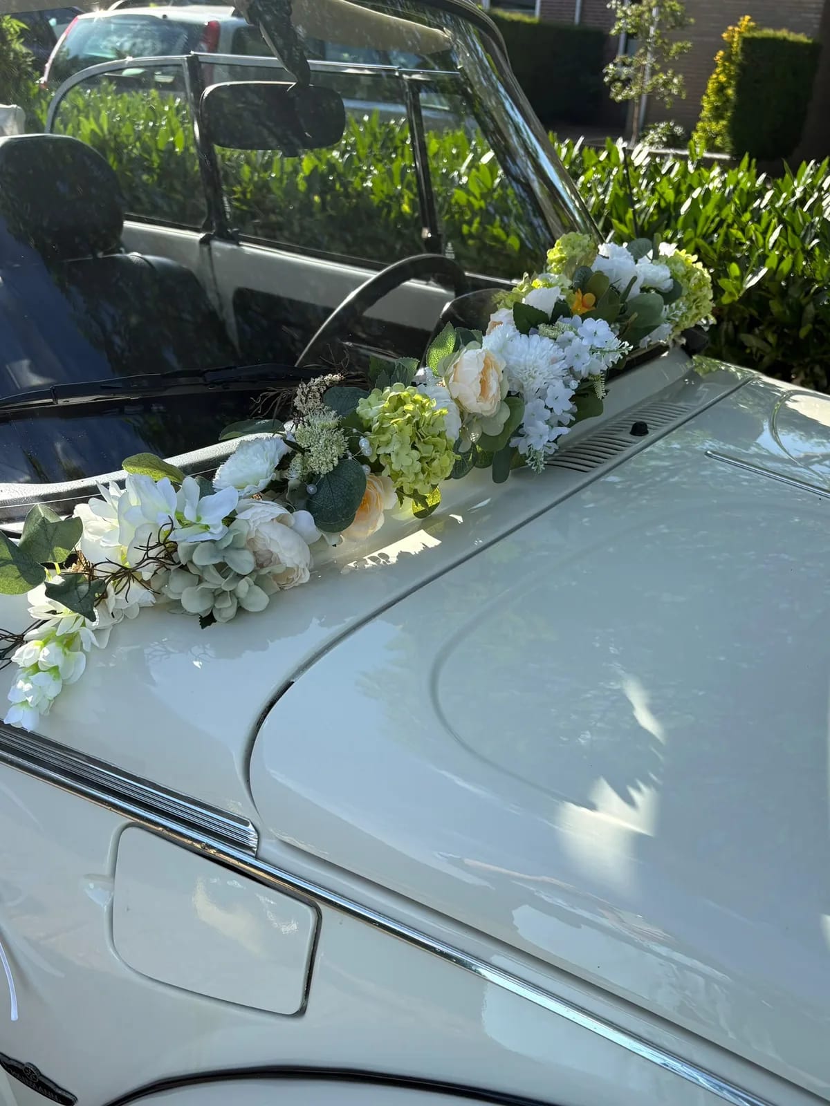 Trouwauto met een arrangement van zijden bloemen